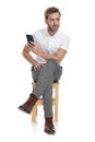 Seated casual man texting on his phone and looks away Royalty Free Stock Photo