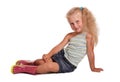 Seated charming little blond girl in blouse, skirt and rubber bo Royalty Free Stock Photo