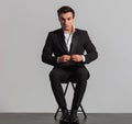Seated elegant man buttoning his suit Royalty Free Stock Photo