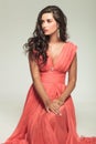 Seated elegant woman in red dress looking to side