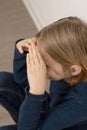 Seated on the floor, a pensive young boy with long locks contemplates deeply, lost in the innocence of childhood reverie Royalty Free Stock Photo