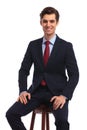 Seated happy business man holding hands on knees
