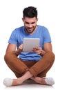 Seated happy casual man working on his tablet Royalty Free Stock Photo