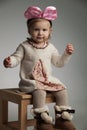 Seated little beautiful girl wearing a pink bow headband Royalty Free Stock Photo