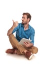 Seated man with tablet pointing or making the ok sign