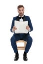 Seated shocked man in blue suit reading newspaper Royalty Free Stock Photo