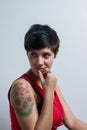 A seated short-hair brunette woman wearing a red tank top looking aside Royalty Free Stock Photo