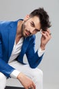Seated smart casual man leaning and fixing his hair Royalty Free Stock Photo