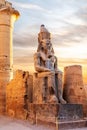 Seated statue of Ramesses II by the Luxor Temple entrance, sunset scenery, Egypt Royalty Free Stock Photo