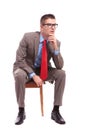 Seated young business man looks away pensively Royalty Free Stock Photo