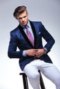 Seated young business man unbuttoning jacket Royalty Free Stock Photo