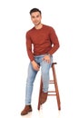 Seated young casual man with hand on thigh Royalty Free Stock Photo