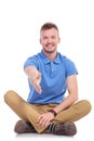 Seated young casual man offers handshake