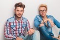 Seated young casual men looking at the camera