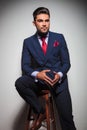 Seated young elegant man in suit and tie looking away Royalty Free Stock Photo