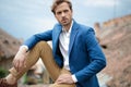 Seated young handsome man looks away to side Royalty Free Stock Photo