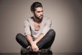 Seated young man with beard looks away Royalty Free Stock Photo