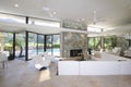 Seating Area And Stone Fireplace In Spacious Living Room With Pool View