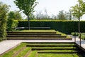 Seating for relaxing in a landscaped park. Minimalist landscape design with green grass steps.