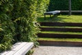 Seating for relaxing in a landscaped park. Minimalist landscape design with green grass steps.