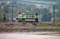 SEATON, DEVON, ENGLAND - MAY 22ND 2012: Two men get out of a green tram to inspect a box fixed to post