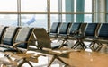 concept of travel, seats in the airport lounge in the rays of the rising sun on the background of windows Royalty Free Stock Photo