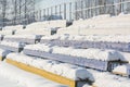 Seats in the stadium under the snow. Chairs for spectators at the stadium under the snow.