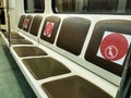 Seats in subway car with a red warning sign about respecting social distance