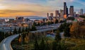 Seattle downtown skyline and skyscrapers beyond the I-5 I-90 freeway interchange at sunset in the fall with yellow foliage in the Royalty Free Stock Photo