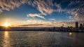 Seattle skyline sunset with water in the foreground and fluffy orange clouds