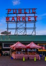 Famous Pike Place Market neon sign with a blue sky in the background and a vendor Royalty Free Stock Photo