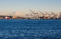 Cargo cranes at the port of Seattle at sunset with Mount Rainier on the background