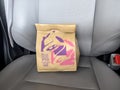 Seattle, WA USA - circa March 2023: Close up view of a Taco Bell fast food bag inside of a car