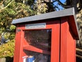 Seattle, WA USA - circa November 2022: Close up view of a red Little Free Library in a residential neighborhood