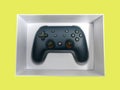 Closeup of a Google Stadia gaming controller inside a white box against a colorful Royalty Free Stock Photo