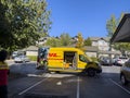 Seattle, WA USA - circa October 2022: Wide angle view of a DHL delivery van making a stop in a large apartment complex on a bright