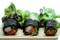 Seaweed salad roll with fresh vegetables and crab stick on wooden plate and white background Royalty Free Stock Photo