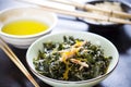 seaweed salad with sesame oil dressing, glass bowl, chopsticks aside