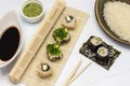 Seaweed sushi set on a bamboo sushi mat. Wasabi and soy sauce in bowls. Rice on a plate. Sushi with cucumber on nori sheet Royalty Free Stock Photo