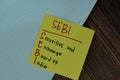 SEBI - Securities and Exchange Board of India write on sticky notes isolated on Wooden Table Royalty Free Stock Photo