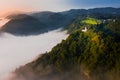 Sebrelje, Slovenia - Beautiful hilltop church of St.Ivan Sv. Ivan Cerkev standing above the morning fog and clouds in the valley Royalty Free Stock Photo