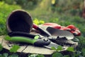 Secateurs and other gardening tools on wooden stump among green grass, closeup