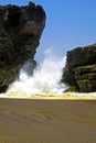 Secluded black lava sand beach cove, powerful heavy violent surf waves breaking between rocks, misty sea spray foam  - Cobquecura Royalty Free Stock Photo