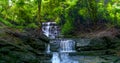 Secluded Cascading Rock Waterfall Amidst Tropical Rain Forest with Stone Full of Moss Under the Tree Canopy Jungle Royalty Free Stock Photo