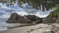 Secluded tropical beach. Waves foam around picturesque boulders. Royalty Free Stock Photo