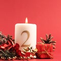 White candle with the number two burns, Advent background