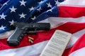 The second amendment and gun control in the US, concept. Handgun, bullets, and the american constitution on the USA flag Royalty Free Stock Photo