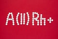 Second blood type. Blood type symbol from white pills on a red background. Blood type treatment Royalty Free Stock Photo