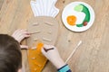 Boy making a carrot from cardboard