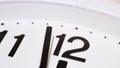 The second hand moves along the dial of an analog clock close-up. The time is 23:59. White dial, black numerals